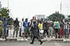 ​A member of Nigerian security forces walks in front of protestors during the End Bad Governance protest in Abuja on August 1, 2024.