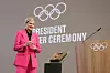 Kirsty Coventry, in a pink suit and black shirt, holds the Olympic key during the IOC presidential handover ceremony at Olympic House on June 23, 2025 in Lausanne, Switzerland.