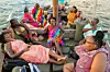A group of women in colorful dresses relax on a dhow.