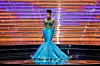 Bonang Matheba on stage at the 2024 Miss South Africa wearing a blue mermaid-style dress with a green beaded corset.