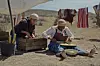 A still photo from Nakhane\u2019s \u2018B(l)ind The Sacrifice\u2019 showing two women - one sitting on the floor and cutting cabbage, and the other arranging some vegetables in a wooden box.