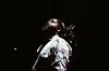 South African artist Sjava looks up while performing onstage during a live show.