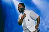 South African artist Sjava smiles onstage during a live show.