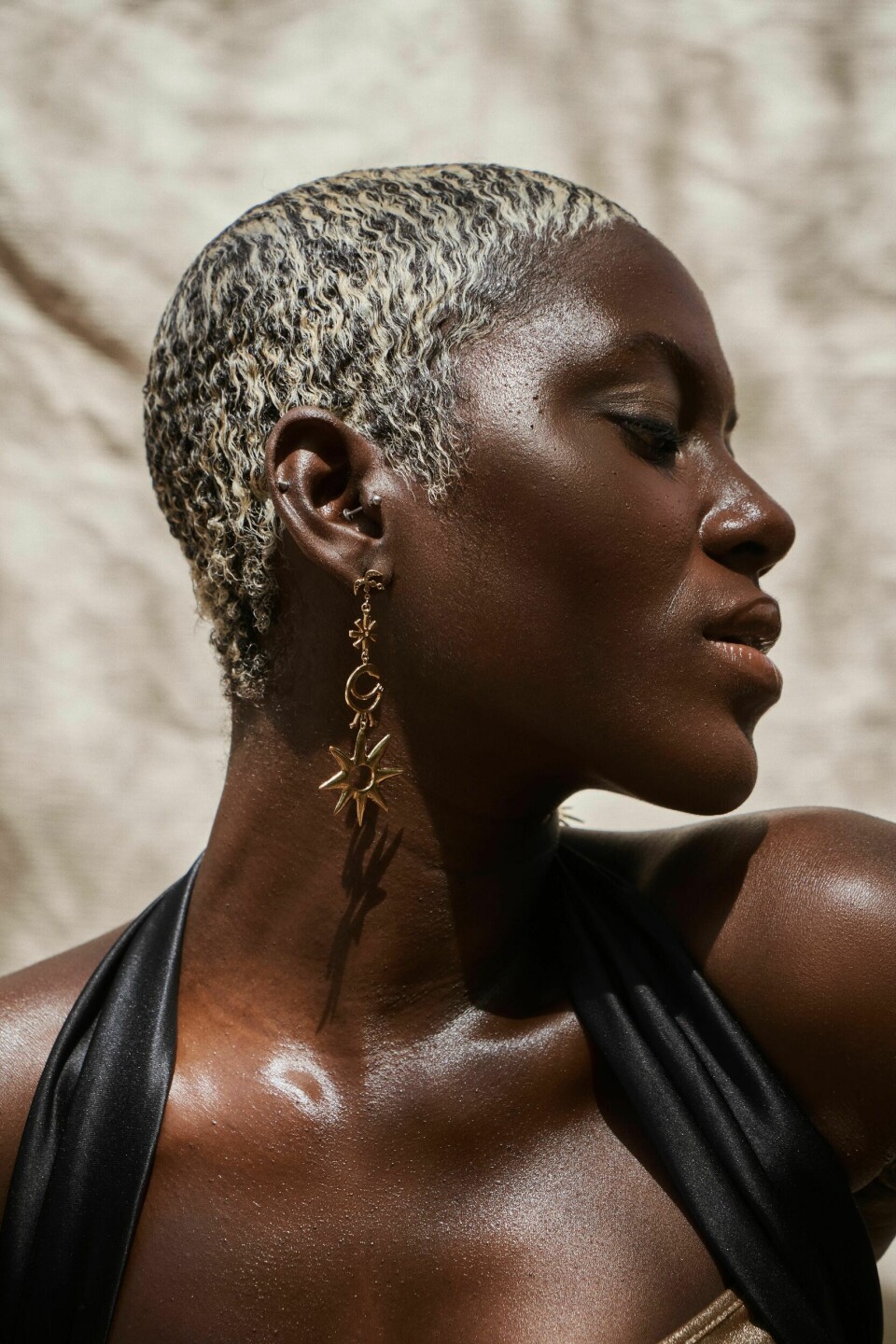Aisha Asamany's luxury jewelry brand is steeped in the tradition of telling authentic Ghanaian stories with bespoke pieces. A model poses with luxury jewelry.