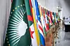 A display of African national flags alongside the African Union flag (foreground, green with a white map of Africa and gold stars), likely at a diplomatic or international event celebrating African unity or cooperation.