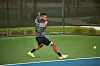 Tennis player Felix Auger hitting a ball while wearing Thebe Magugu