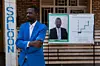 A photo of Rwandan independent candidate Philippe Mpayimana posing next to an electoral poster of himself days before the nation goes to the polls in Shyrongi, north of Kigali on July 29, 2017.