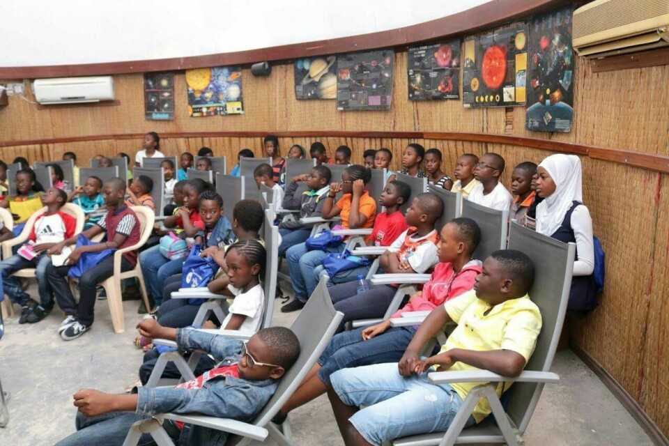Every year, the planetarium receives approximately 25,000 visitors, with the majority being school children. An image of children sitting inside the Ghana Planetarium.