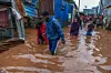 Residents are seen in a flooded street of Mathare neighborhood after heavy rains as they try to evacuate the area with their important belongings in Nairobi, Kenya on April 24, 2024.