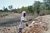 Farmer Takesure Chimbu arranges additional stones to the wall of the Kapotesa dam, which has run completely dry because of the El-Nino induced drought, in Mudzi on July 2, 2024.