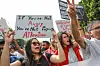 A young female demonstrator shouts slogans as she raises a placard that reads, ''If you are not angry, you are not paying attention,'' during a demonstration organized by the Tunisian Network for Rights and Freedoms in Tunis, Tunisia, on September 22, 2024, to protest the draft amendment to the electoral law.