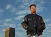 Nasty C posing to a background of clouds and the sky.