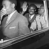 Former Congolese Premier Patrice Lumumba flashes a big smile and waves as he leaves Idlewild Airport for Manhattan, following his arrival in New York on July 24, 1960.