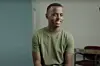 A still from a video showing Heman Bekele in a sitting position and wearing a green t-shirt.