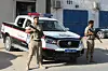 Two Libyan police officers stand in front of a police vehicle in the capital Tripoli.