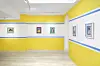 Yellow, blue, and white-painted gallery walls adorned with small-scale prints of Hajjaj's photography.