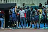 Nairobi City Thunder basketball players in uniform gather around their coach during an indoor game.
