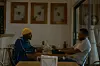 A still from 'All the Colours of the World' of two men sitting in a restaurant.