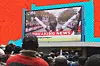 A photo of people watching Kenya's Eliud Kipchoge run a marathon in under two hours.