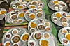 Traditional Sudanese trays are laid on the floor with small plates of lentils, dates, and asidah.