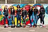 A group of women motorcyclists pose with their helmets in front of their feet.