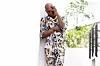 Seun Kuti stands in the distance in a colorful multi-patterned outfit.