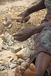 A woman's hands hammering stones