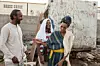 An image of the director Khadar Ayderus Ahmed laughing with his film's stars Yasmin Warsame and Omar Abdi on set of 'The Gravedigger's Wife' in Djibouti.