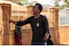 Espoir Kahitani passionately performing spoken word poetry outside, wearing a black shirt