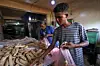 People bagging bread in pink plastic bags in a bakery