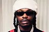 Still shot of Naira Marley with sunglasses and beanie.