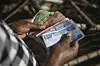 A shop owner counts Ethiopian Birr in his stall at the Shola Market in Addis Ababa on December 4, 2023.