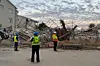 Officials are seen at the scene of a collapsed building in George, South Africa on May 7, 2024.