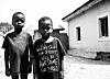 A black and white image of two young boys in Yeyedu Community looking at the camera.