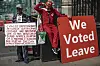 A man holds a sign protesting for the independence of Chagos Islands, alongside Pro Brexit protesters outside the Houses of Parliament on July 3, 2019 in London, England.