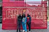 Nyasha Kadandara stands between Jordan Inaan and Sam Soko in front of a red backdrop with 'CPH:DOX' signage at the documentary film festival in Copenhagen.
