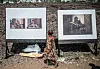 A young girl walks between two blown-up photographs on stands