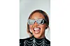 Ayishe Molefe wears dark shades, smiles at the camera.