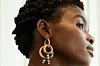 A model wears a golden ear ring designed by African jewelry designer Katherine-Mary Pichulik.
