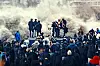 An image from the film \u2018Les Indesirables\u2019 of men standing on podiums in a cloud of smoke, as onlookers surround them.