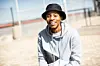 Kgotso Motingwe smiles in a grey hoodie and a black bucket hat.