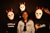 A photo of Sara Chitambo, surrounded by three people wearing masks, with t-shirts that had the inscriptions: anxiety and childhood trauma on two of them.