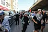 A group of Tunisians runs in front of buses carrying pro-Palestinian participants in the Resilience Convoy