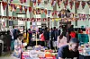 A book fair with people browsing tables full of books, with colorful bunting and African-inspired decor overhead.