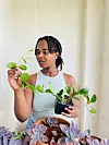 Wakisha Wazome inspecting a trailing plant in a black pot.