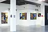 Various artworks hung on a plain white wall.