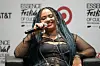 Moliy smiles and speaks into a mic; she is seated on a black leather chair, her hair in braids, in the background, the words: Essence Festival of Culture