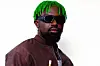 Afrobeats songwriter Mbryo sports green-colored braids and dark sunglasses