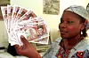 A woman holds 10,000 CFA franc banknotes in her hand