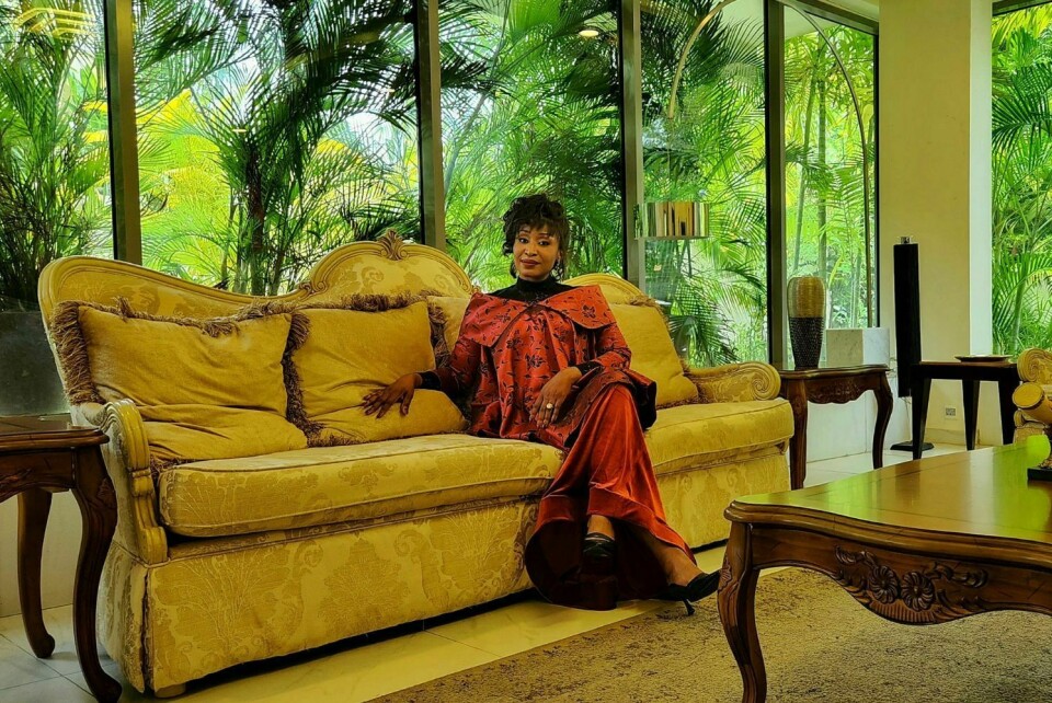 Ashionye Raccah is the first Nigerian actor from Nollywood to star on the hit Netflix series Wednesday. She stars alongside Thandie Newton and Jenna Ortega Ashionye Raccah poses while sitting on a couch behind a large glass window overlooking lush greenery.